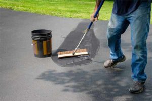 Freehold New Jersey sealcoating, Homeowner applying sealcoating to their Freehold New Jersey driveway